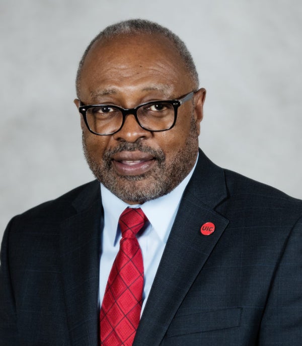 UHP Executive Director Dr. Darryl Pendleton: an African American man wearing glasses and a dark blue suit coat, light blue shirt and red neck tie.