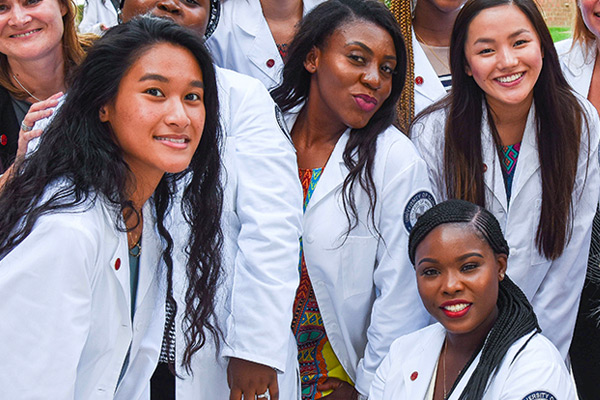 diverse group of sgtudent wearing white coats